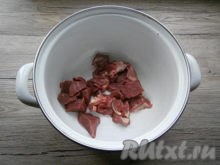 Говядину нарезать средними кусочками и поместить в кастрюлю.