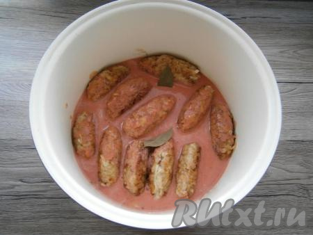 Получившийся томатно-сметанный соус тщательно перемешать и залить им ленивые голубцы, на забывая полить их и сверху. Сюда же добавить и пару лавровых листьев. Голубцы должны быть практически полностью покрыты соусом. Довести томатно-сметанный соус до кипения, убавить огонь, накрыть крышкой, тушить ленивые&nbsp;голубцы с капустой, рисом и фаршем минут 20, периодически поливая голубцы сверху соусом.