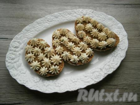 Отсадить сырную массу на хлеб в виде небольших цветочков-звездочек.