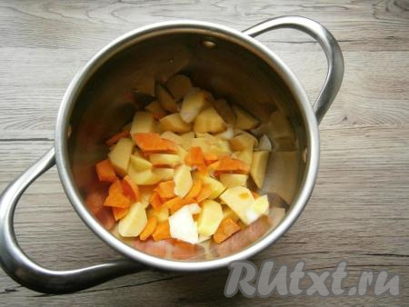 Очищенную морковь нарезать произвольно и тоже выложить в кастрюлю.