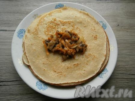 На каждый блин выкладывать по столовой ложке грибной начинки.