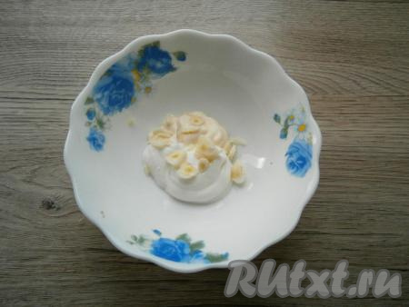 Смешать майонез со сметаной, добавить нарезанный кусочками очищенный чеснок, перемешать получившуюся массу.
