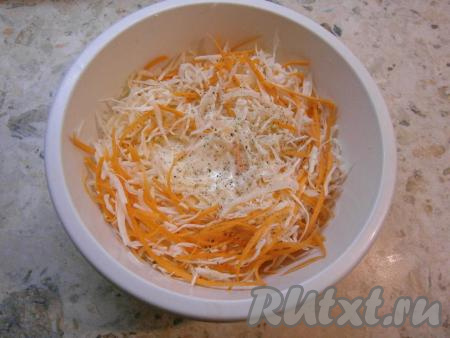 Вылить заправку в салат из капусты и моркови, поперчить хорошенько черным и белым перцами.