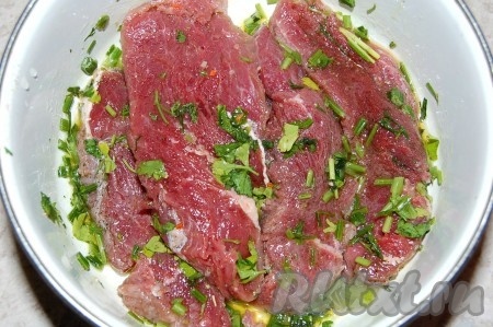 Сложить куски мяса в миску, добавить нарезанную зелень, оливковое масло. Перемешать.