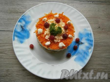 Убрать аккуратно кулинарное кольцо, по слою моркови разместить капли майонеза, украсить салат веточкой зелени и ягодами.