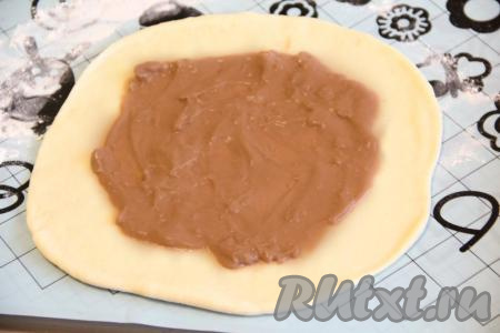 Лепёшку из теста смазать варёной сгущёнкой, отступив от краёв лепёшки по 1-2 сантиметра.