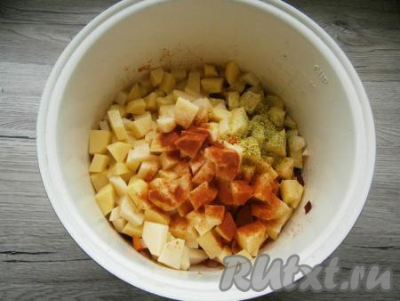 Затем добавить нарезанный кубиками картофель, всыпать приправу для овощей, соль по вкусу, а также паприку. Влить горячую воду, перемешать, выставить режим "Тушение" на 1 час, крышку мультиварки закрыть.