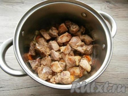 На сковороду налить 2-3 столовые ложки растительного масла, добавить кусочки свинины, обжарить их на среднем огне до небольшой румяности со всех сторон, затем выложить мясо в кастрюлю поверх овощей.