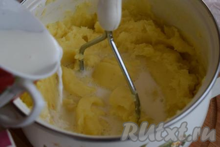 В конце приготовления пюре надо развести горячим молоком до нужной консистенции. Кто-то любит пюре пожиже, кто-то - погуще. Поэтому может понадобиться разное количество молока. Добавляя молоко, ориентируйтесь на свой вкус. Понемногу добавляем молоко в картофельное пюре и с помощью толкушки разминаем его до однородности.
