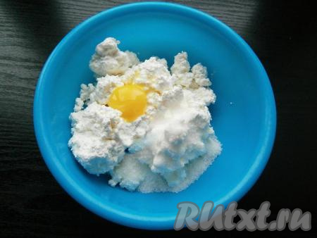 Пока тесто для вареников "отдыхает", можно заняться начинкой. Прежде всего изюм нужно промыть водой, выложить в глубокую тарелку, залить полностью кипящей водой, оставить минут на 5, после этого воду слить. Разложить изюм на бумажном полотенце, дать обсохнуть. В достаточно глубокую миску выложить творог любой жирности, добавить сырое яйцо и сахар.