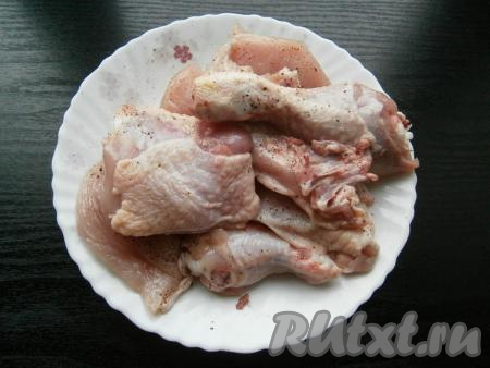 Посолить кусочки курицы, посыпать молотым перцем и специями.