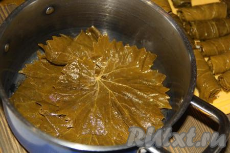 Кастрюлю для приготовления долмы выстелить листьями винограда.