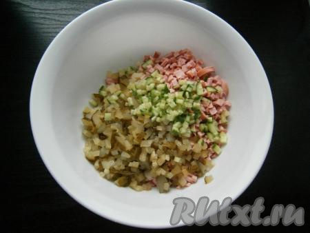 В салат из картошки и колбасы добавить свежий и маринованный огурчики, нарезанные маленькими кубиками.