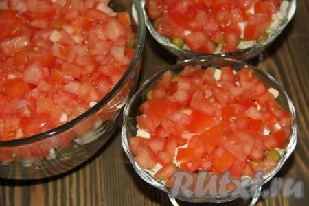 Помидоры вымыть, нарезать кубиками и выложить поверх яиц, смазанных майонезом. 
