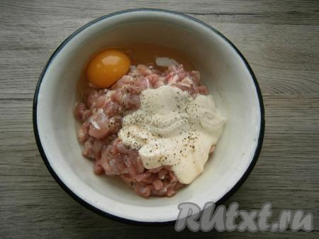 Куриную грудку разделить на филе. Филе промыть водой, обсушить, нарезать острым ножом на очень мелкие кусочки, выложить в миску. Добавить к мясу сырое яйцо и майонез, посолить и поперчить, перемешать.