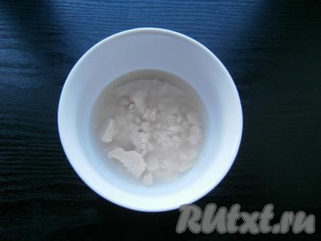 В теплую воду раскрошить дрожжи, перемешать их до растворения.