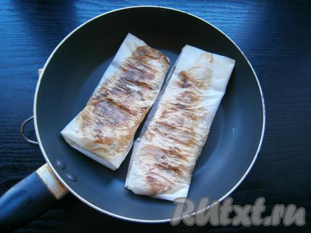 Разогреть сухую сковороду, выложить куриное филе в пергаменте. Жарить на среднем огне 6-8 минут, каждые 2 минуты курицу нужно переворачивать.