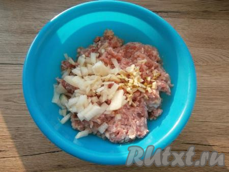 В мясной фарш добавить очищенные и мелко нарезанные репчатый лук и чеснок.