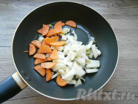 Морковь и лук очистить. Лук нарезать произвольными кусочками, морковь - полукружочками, выложить их на сковороду, разогретую с 2 столовыми ложками растительного масла.