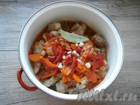 Залить в кастрюлю с кусочками свинины приготовленный соус, добавить нарезанный чеснок и лавровый лист.