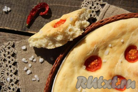 Выпекать фокаччу с помидорами в разогретой духовке при температуре 200 градусов, примерно, 25 минут. Выпечка покроется красивой золотистой корочкой. Аналогично испечь вторую фокаччу. Готовую итальянскую лепёшку слегка остудить под полотенцем. Посмотрите, какая она аппетитная внутри.