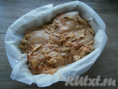 Форму для запекания застелить пергаментной бумагой. Выложить в форму куриные бедра, замаринованные в соевом соусе.