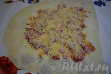 Посыпаем колбасу сыром, натертым на терке.