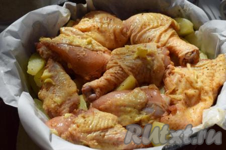 Поверх картофеля выкладываем кусочки курицы, смазываем оставшимся размягченным сливочным маслом. 