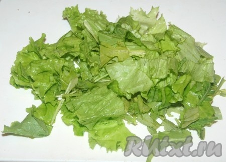 На блюдо выложить вымытый и обсушенный  крупно нарезанный листовой салат.