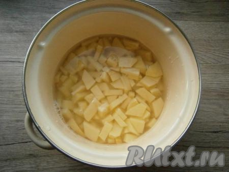 Картофель, морковь, чеснок и лук очистить, из болгарского перца удалить семенную коробку. Картофель нарезать кубиками в кастрюлю, влить воду, поставить кастрюлю на огонь. Варить картошку на небольшом огне, посолив воду по вкусу, 25-30 минут (картофель должен начать развариваться).