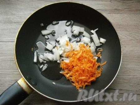 Лук нарезать кусочками, морковь натереть на крупной терке, выложить овощи в сковороду, влить растительное масло.