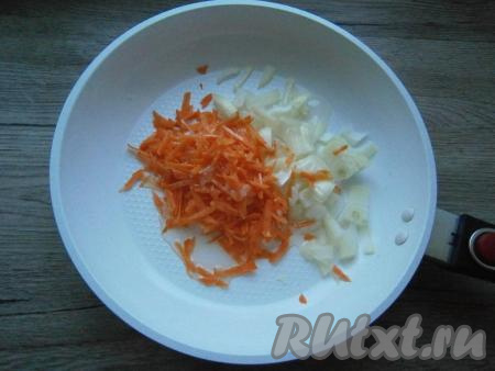 В ту же сковороду влить оставшееся растительное масло, выложить 0,5 луковицы, нарезанной кусочками,  и натертую на крупной терке морковь.