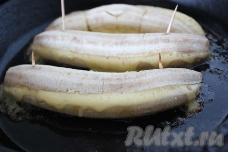 Запечь бананы с сыром на смазанном сливочным маслом противне в духовке при 200 градусах до расплавления сыра.