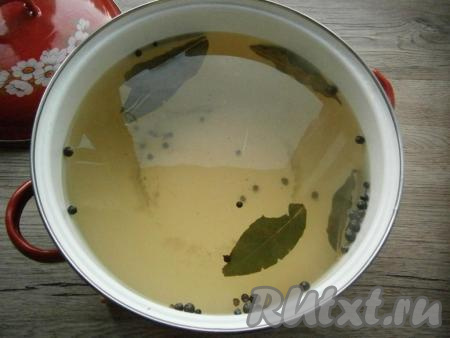 Затем воду слить в раковину и снова залить огурцы кипятком, оставив их на 10 минут. Приготовить маринад: вскипятить 3 литра воды, всыпать соль и сахар, добавить лавровые листья, горошины душистого и черного перца, проварить 3-4 минуты, после чего влить уксус, снова довести до кипения.