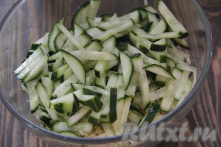 Огурчики вымыть, нарезать длинными брусочками и добавить к капусте.