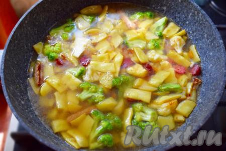 Накрываем сковороду крышкой, доводим до кипения, уменьшаем огонь до минимального и начинаем тушить наш суп "Айнтопф".