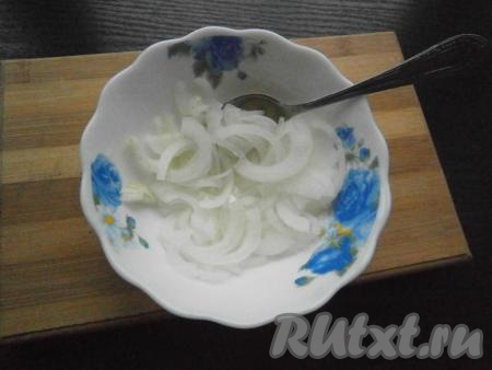 Очищенный лук нарезать тонкими полукольцами, ошпарить его кипятком, затем залить уксусом и оставить мариноваться на 5-7 минут.