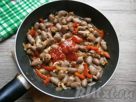 Влить соевый соус, перемешать и обжарить куриные сердечки с овощами 3-4 минуты на среднем огне, иногда перемешивая. Далее добавить в сковороду томатный соус.