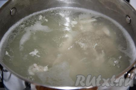 В кастрюлю выложить части курицы, залить водой и поставить на огонь. После закипания уменьшить огонь, снять пену и варить мясо минут 30 с момента закипания. Затем вынуть мясо, отделить его от костей и вернуть в кастрюлю с бульоном, довести до кипения.