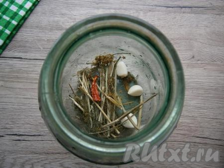На дно чистой банки выложить укроп, зубчики чеснока, перец чили.