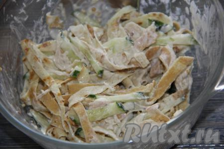 Добавить заправку в салат из куриной грудки, огурца и блинчиков, хорошо перемешать.