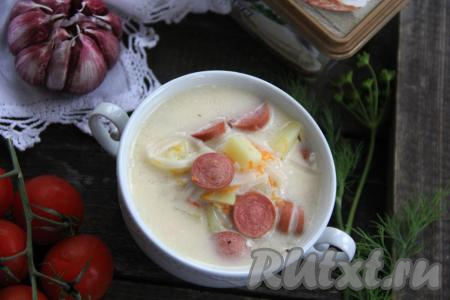 Подать сытный, вкусный суп с плавленным сыром и сосисками в горячем виде к столу.