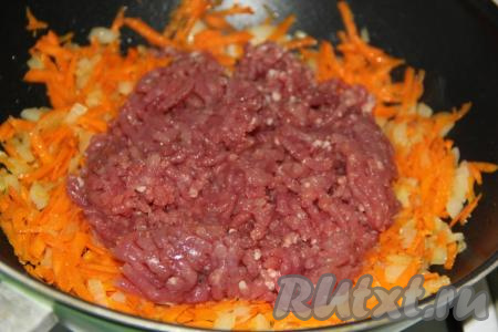Затем добавить фарш в сковороду. Обжаривать свиной фарш с овощами в течение минут 15 на среднем огне, помешивая и разбивая комочки мяса.