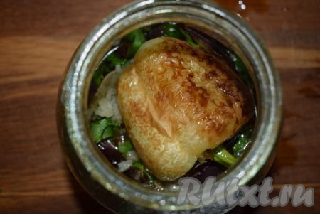 Выкладываем перцы на баклажаны в банку, посыпаем 1/3 частью чеснока и зелени, накрываем банку крышкой.