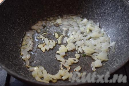 В это время приготовим начинку для нашего грибного пирога. Для этого грибы переберем, промоем и отварим в подсоленной воде в течение 20 минут с момента закипания, затем откинем на дуршлаг. Если вы используете замороженные грибы, также как и я, то сначала следует их разморозить при комнатной температуре или же подставить замороженные грибы под холодную воду. Размороженные грибы отжать от лишней влаги. Я замораживаю уже отваренные грибы, поэтому этап варки я пропускаю, только размораживаю и убираю лишнюю влагу. Нарежем очищенную луковицу на кубики. В сковороду нальем растительное масло и обжарим лук, помешивая, до легкого подрумянивания.