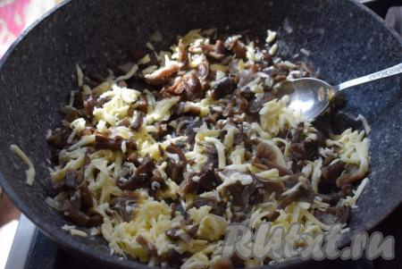 Обжарим грибы с луком на медленном огне в течение 20-25 минут (до готовности грибов). Затем готовые грибы снимаем с огня, добавляем к ним сыр, натертый на крупной терке, перемешиваем грибную начинку для пирога до полного расплавления сыра.