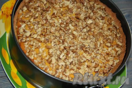 Но я решила, не вынимая выпечку из формы, украсить её орехами и карамелью. Орехи крупно порубить ножом и выложить поверх тыквенного чизкейка.