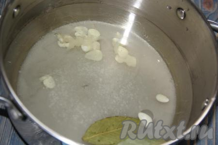 Для приготовления маринада влить воду в кастрюлю, добавить сахар, соль, лавровые листья, очищенный чеснок, нарезанный тонкими пластинками.