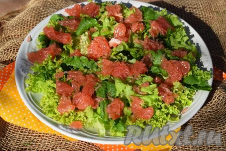 Выкладываем кусочки мякоти грейпфрута на листья салата.