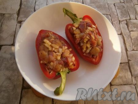 Половинки перца плотно заполнить мясной начинкой, выкладывая её горкой.